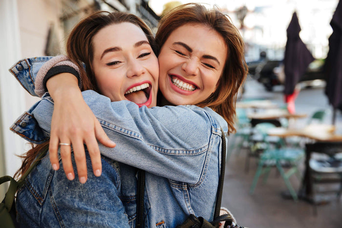 women hug each other and smile in a classroom